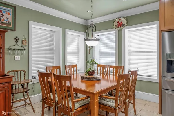 a kitchen with a stove a sink a kitchen island with chairs and wooden cabinets