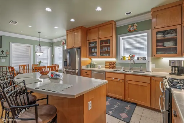 a large kitchen with kitchen island a sink table and chairs