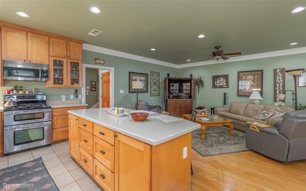 6340 Pine Hill Road Shreveport, LA 71107 - Photo 40 of 40 Kitchen featuring stainless steel appliances, recessed lighting, open floor plan, glass insert cabinets, and crown molding