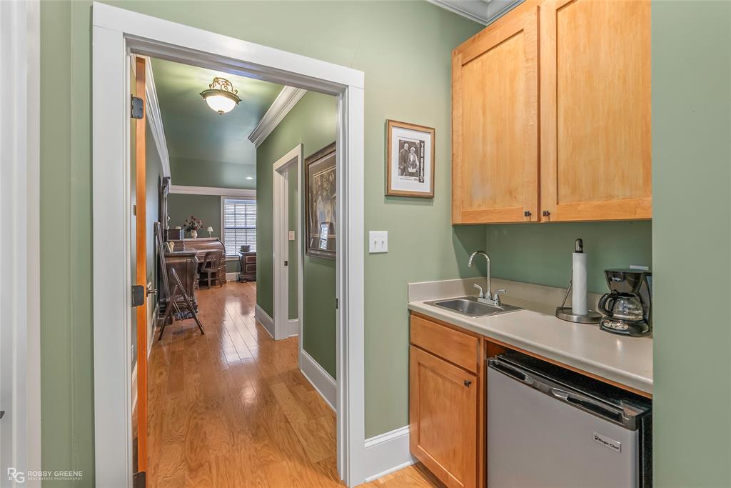6340 Pine Hill Road Shreveport, LA 71107 - Photo 25 of 40 Kitchen with ornamental molding, light countertops, light wood finished floors, and stainless steel dishwasher