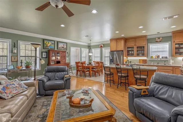 a living room with furniture kitchen view and a large window