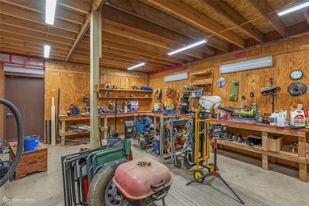 6340 Pine Hill Road Shreveport, LA 71107 - Photo 36 of 40 Garage with a workshop area, wood walls, and a wall mounted AC