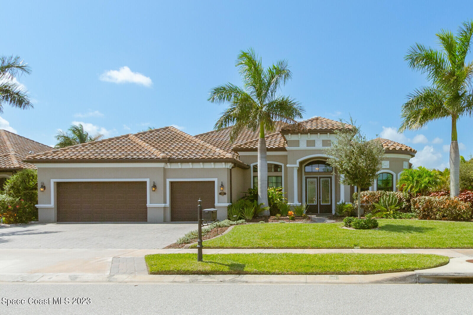 5107 Kirkwall Circle Melbourne, FL 32940 - Photo 2 of 44 a front view of a house with a garden and palm trees