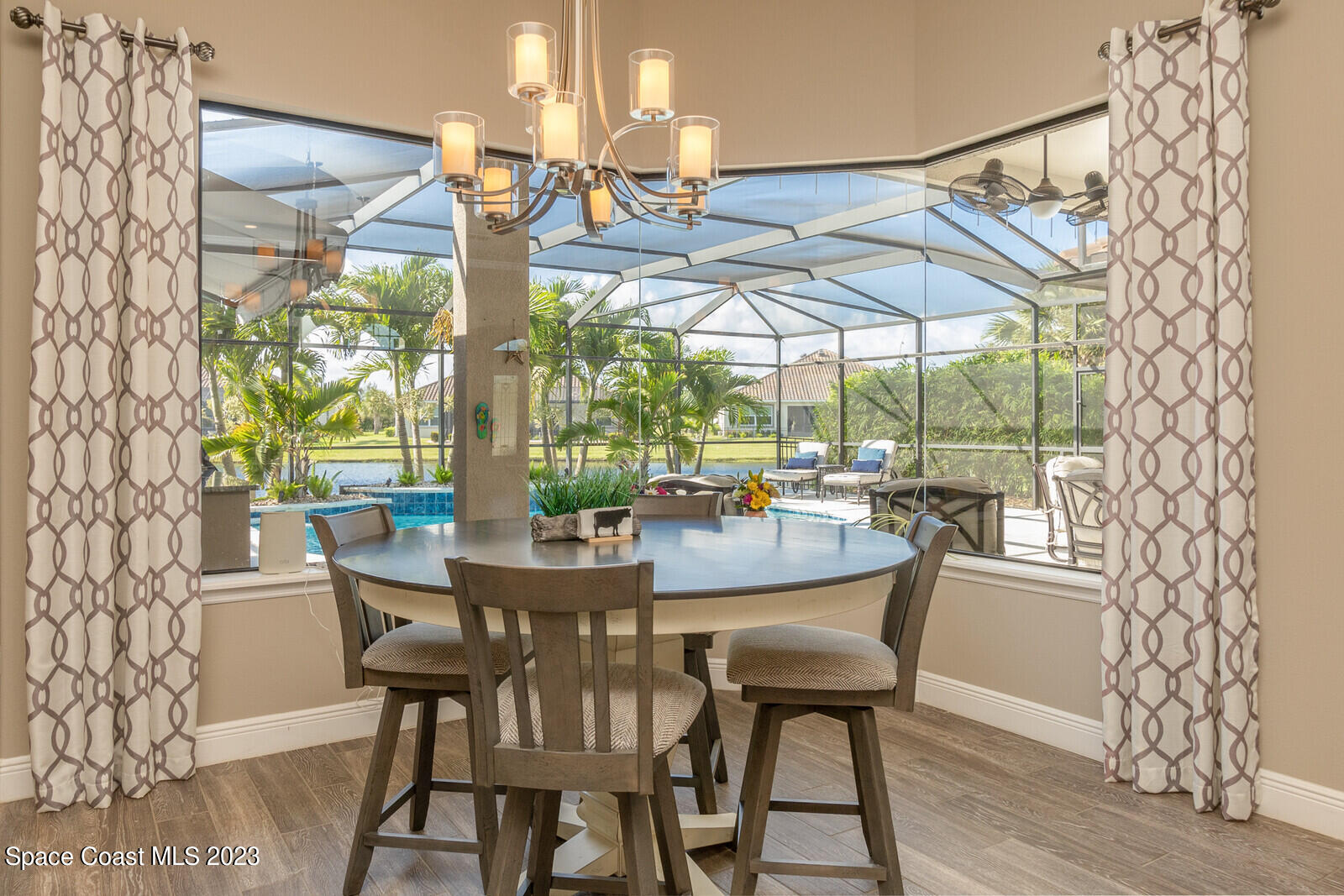 5107 Kirkwall Circle Melbourne, FL 32940 - Photo 27 of 44 a dining room with furniture a chandelier and wooden floor