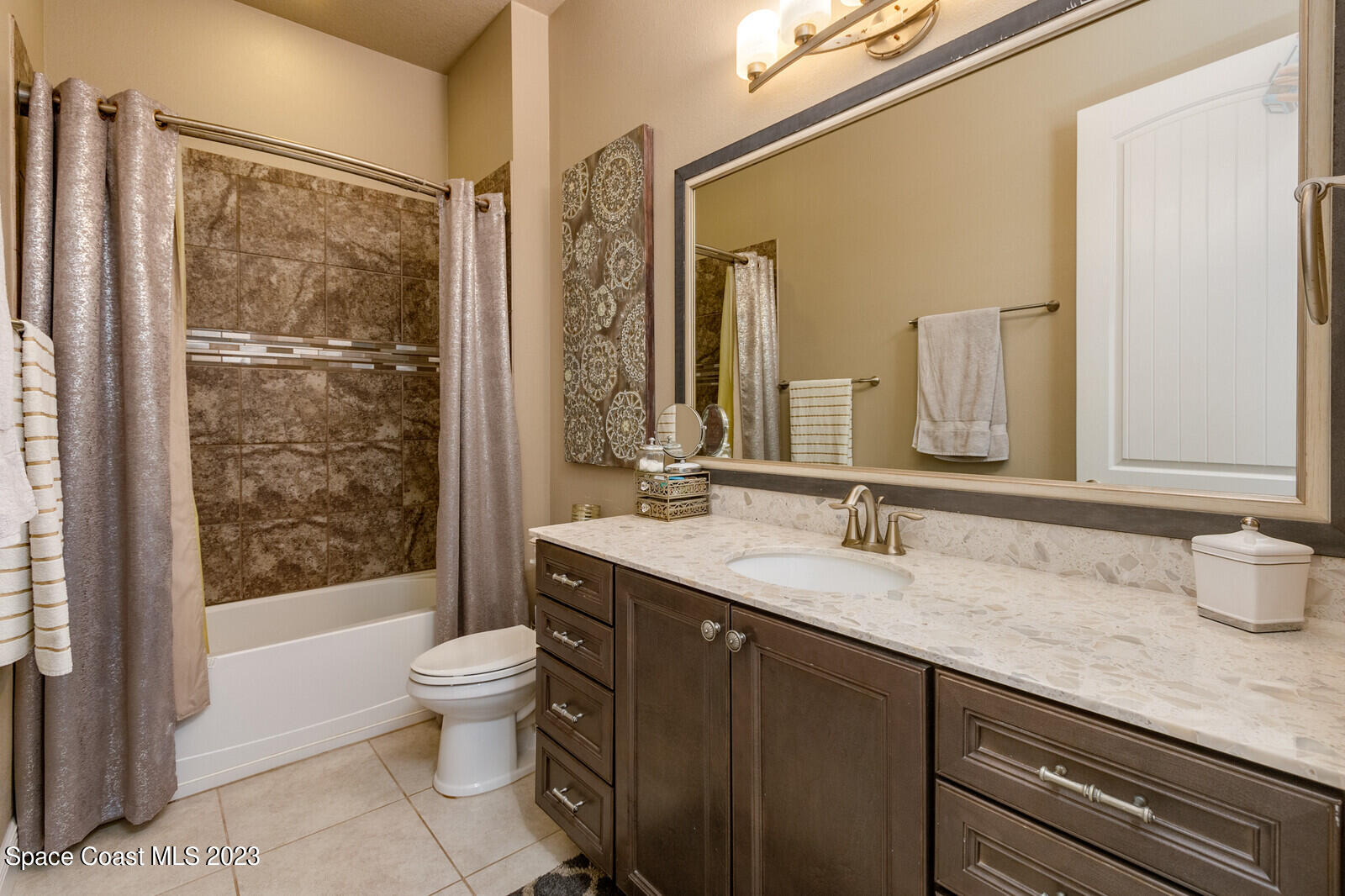 5107 Kirkwall Circle Melbourne, FL 32940 - Photo 35 of 44 a bathroom with a granite countertop sink a toilet a mirror and shower