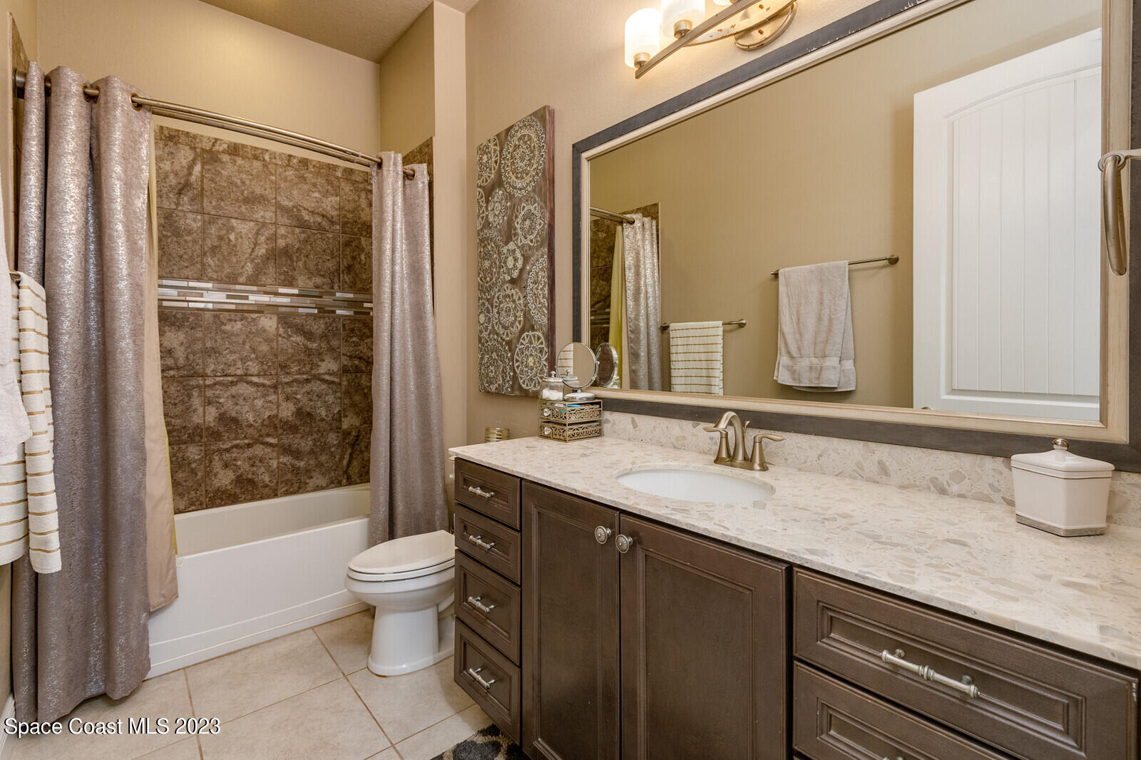 5107 Kirkwall Circle Melbourne, FL 32940 - Photo 38 of 44 a bathroom with a granite countertop sink a toilet a mirror and shower