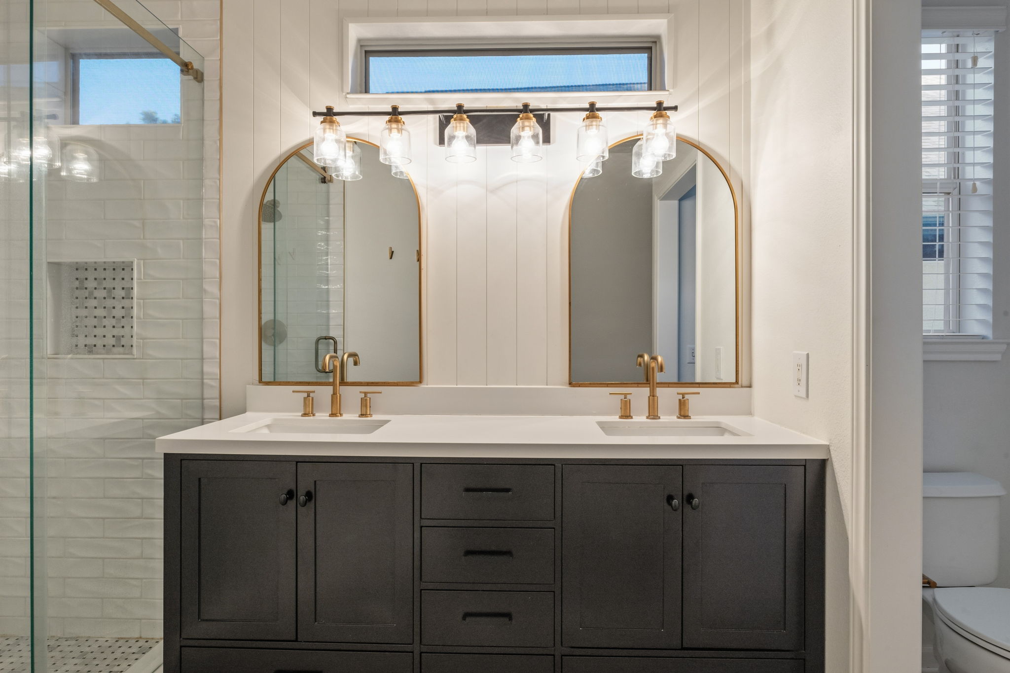 137 Trail Rider Way Georgetown, TX 78633 - Photo 14 of 29 Dual vanity with elegant gold fixtures and arched mirrors creates a refined aesthetic.