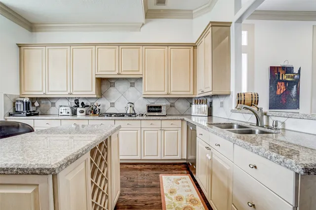 a kitchen with granite countertop a sink a stove and cabinets
