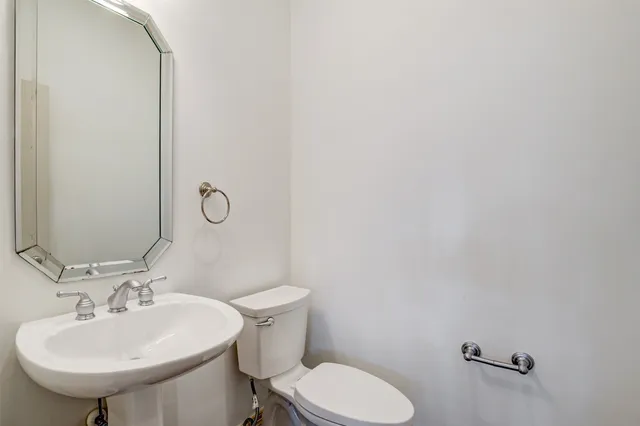 a bathroom with a sink toilet and a mirror