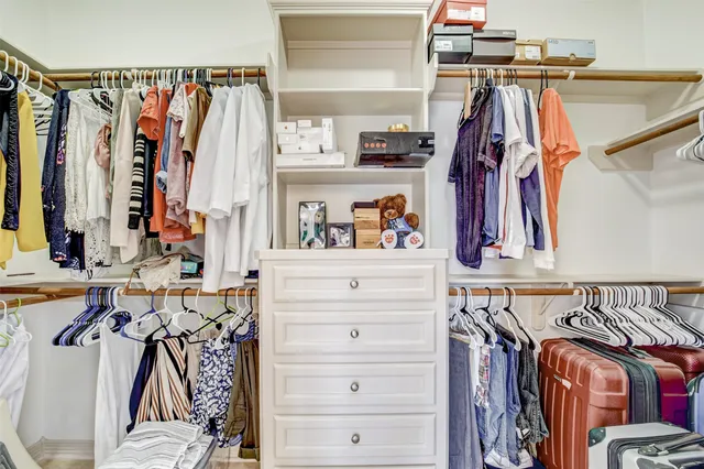 a view of walk in closet with clothes and shoes