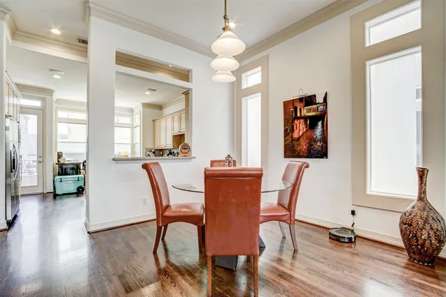 a view of a a dining room with furniture window and wooden floor