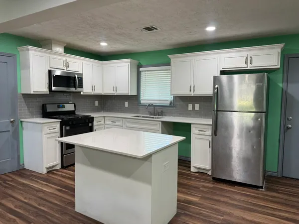 a kitchen with stainless steel appliances a refrigerator sink and microwave