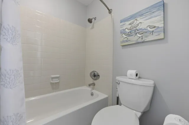 a white toilet sitting next to a bath tub