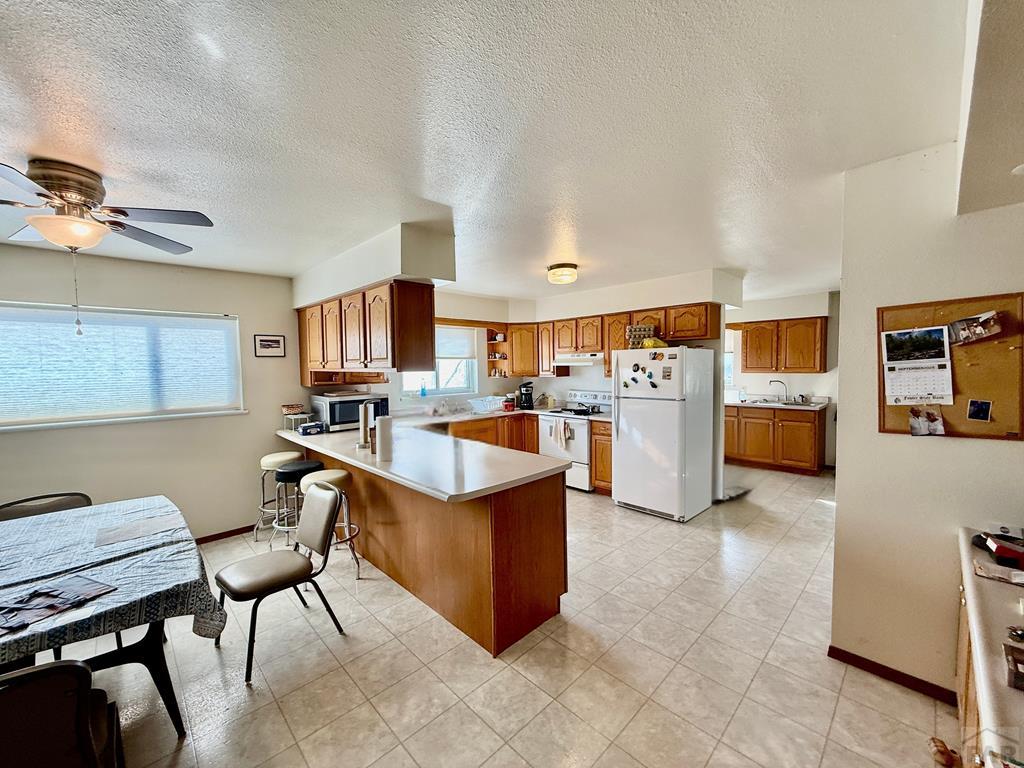 6216 Moreland Road Boone, CO 81025 - Photo 12 of 40 a large white kitchen with lots of counter space and appliances