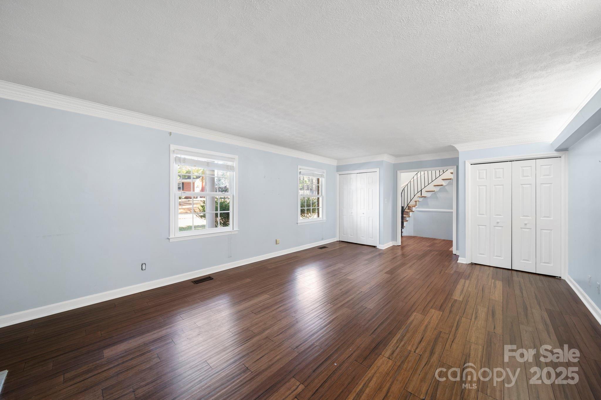 415 Love Lane Rockingham, NC 28379 - Photo 14 of 46 an empty room with wooden floor and windows