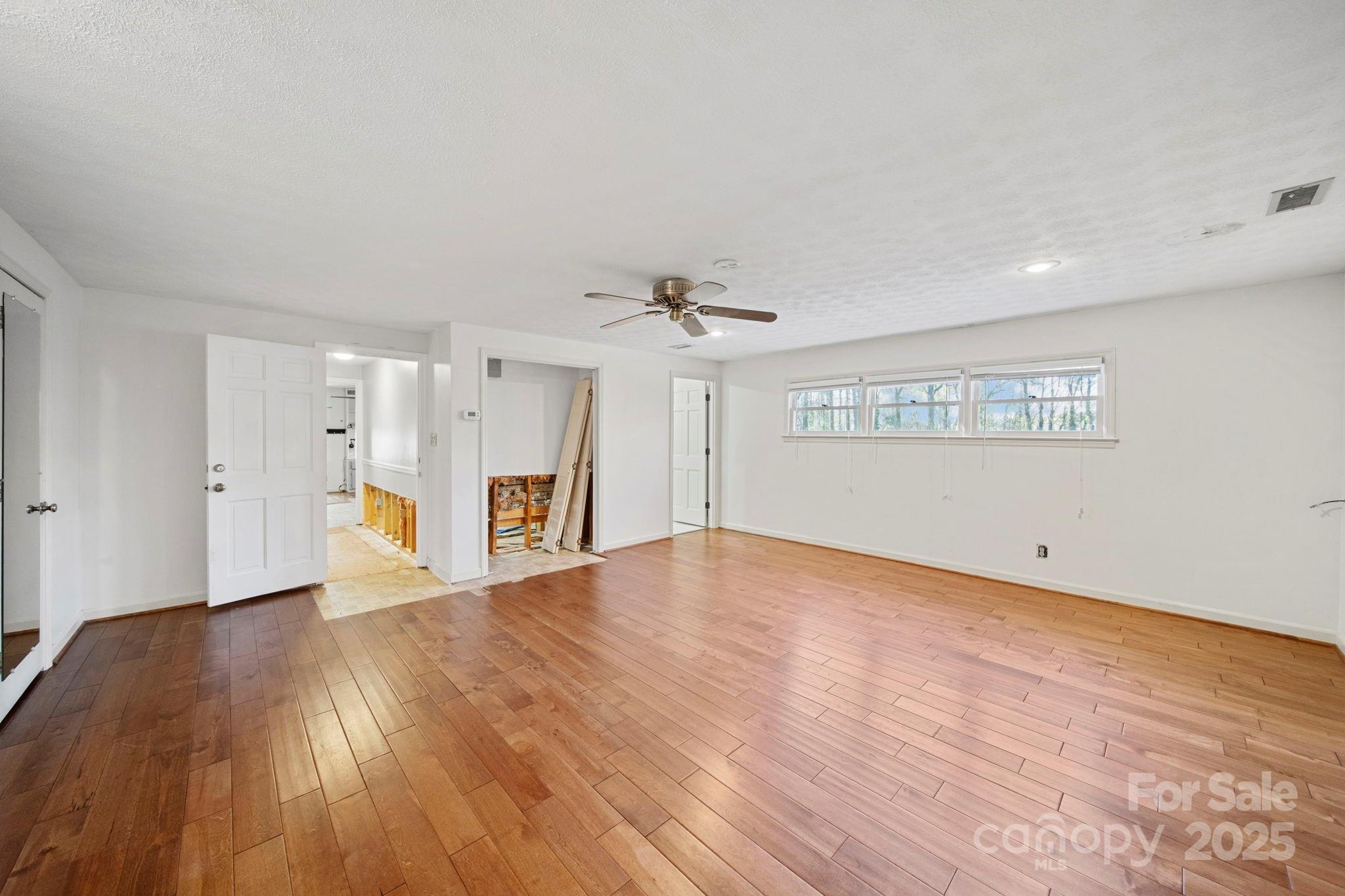 415 Love Lane Rockingham, NC 28379 - Photo 32 of 46 a view of an empty room with wooden floor and a ceiling fan