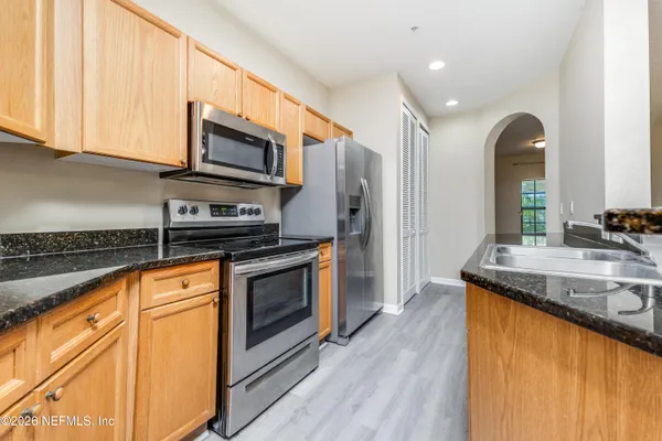 a kitchen with stainless steel appliances granite countertop a stove a sink and a microwave