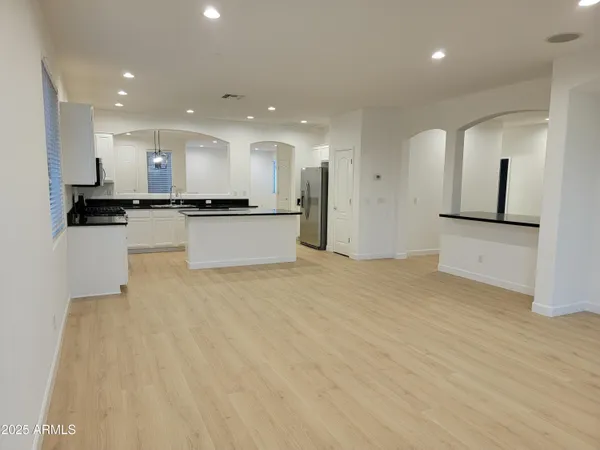 a large kitchen with stainless steel appliances a large counter top a stove and a refrigerator