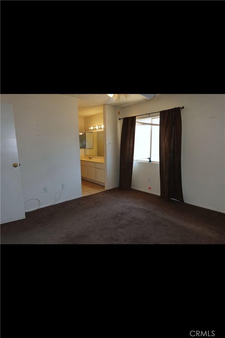 10403 Buckboard Circle Adelanto, CA 92301 - Photo 14 of 20 a view of an empty room with wooden floor and a window