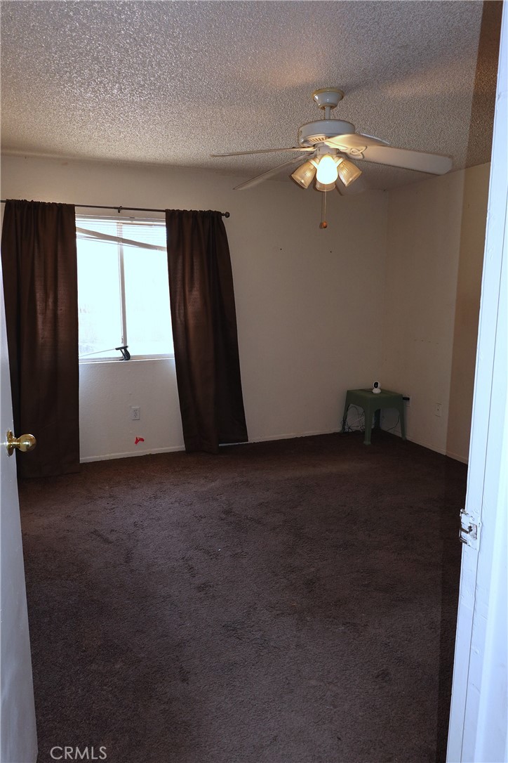 10403 Buckboard Circle Adelanto, CA 92301 - Photo 15 of 20 a view of room with a ceiling fan and a window