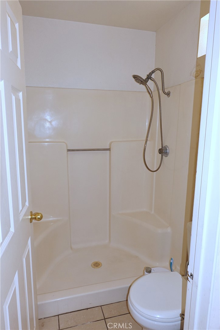 10403 Buckboard Circle Adelanto, CA 92301 - Photo 16 of 20 a bathroom with a shower and a toilet