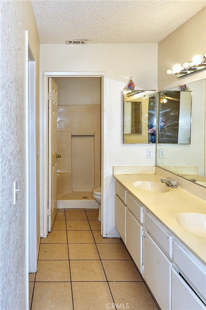 10403 Buckboard Circle Adelanto, CA 92301 - Photo 8 of 20 a bathroom with a granite countertop sink a mirror and a bathtub
