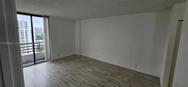 an empty room with wooden floor and sliding door