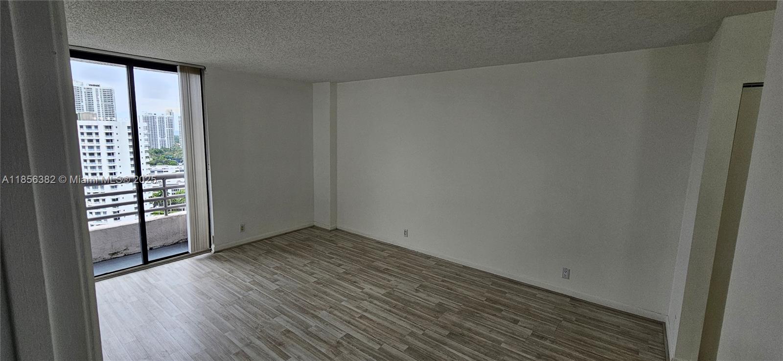 3300 Northeast 191st Street, Unit PH8 Aventura, FL 33180 - Photo 14 of 35 an empty room with wooden floor and windows