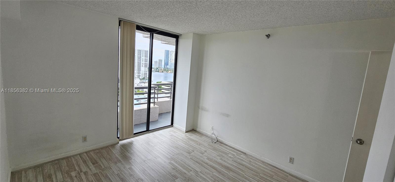 3300 Northeast 191st Street, Unit PH8 Aventura, FL 33180 - Photo 16 of 35 a view of an empty room with wooden floor and a window