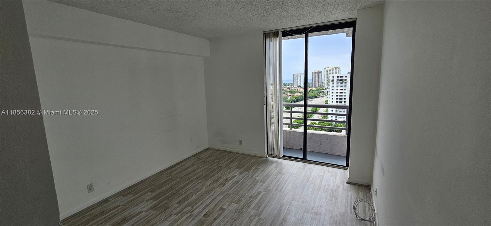 3300 Northeast 191st Street, Unit PH8 Aventura, FL 33180 - Photo 17 of 35 a view of an empty room with wooden floor and a window