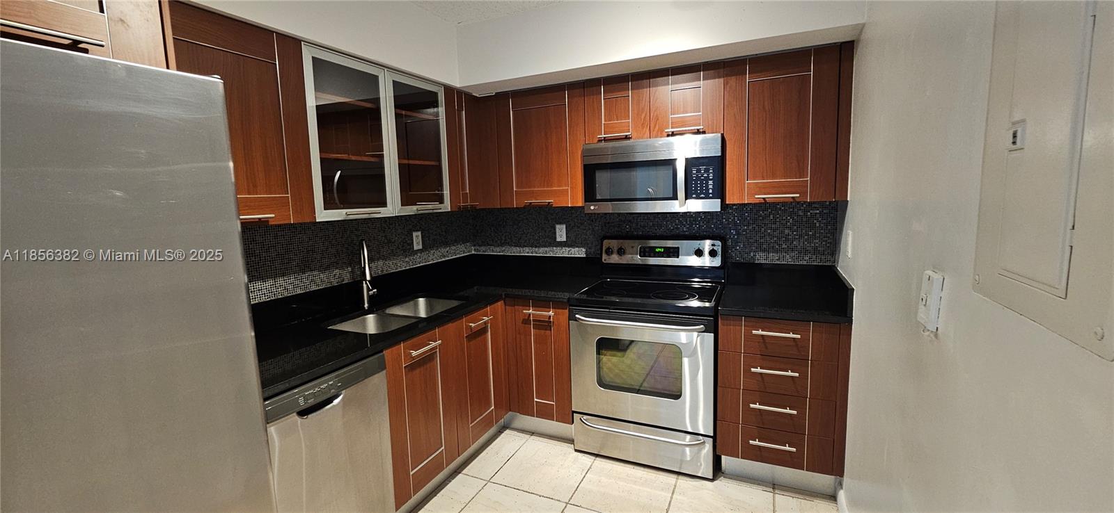 3300 Northeast 191st Street, Unit PH8 Aventura, FL 33180 - Photo 6 of 35 a kitchen with stainless steel appliances granite countertop a stove and a microwave