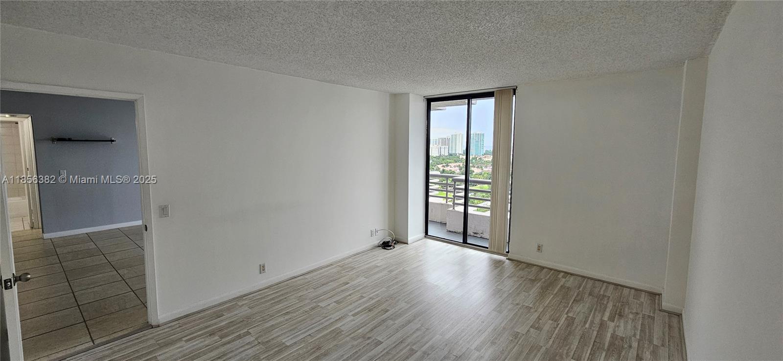3300 Northeast 191st Street, Unit PH8 Aventura, FL 33180 - Photo 9 of 35 an empty room with wooden floor and windows