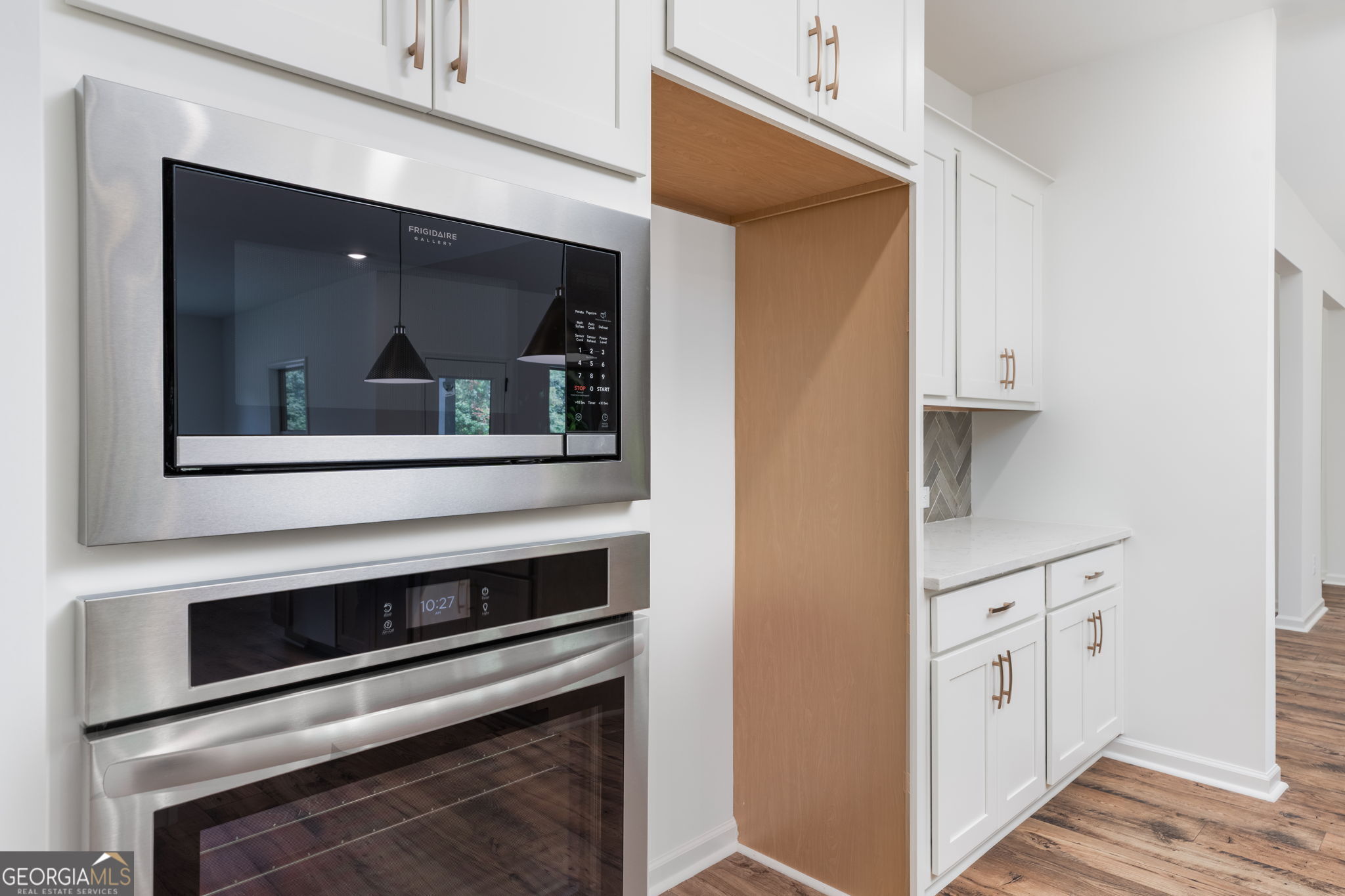 297 Bishop Road Meansville, GA 30256 - Photo 22 of 77 a kitchen with white cabinets and stainless steel appliances