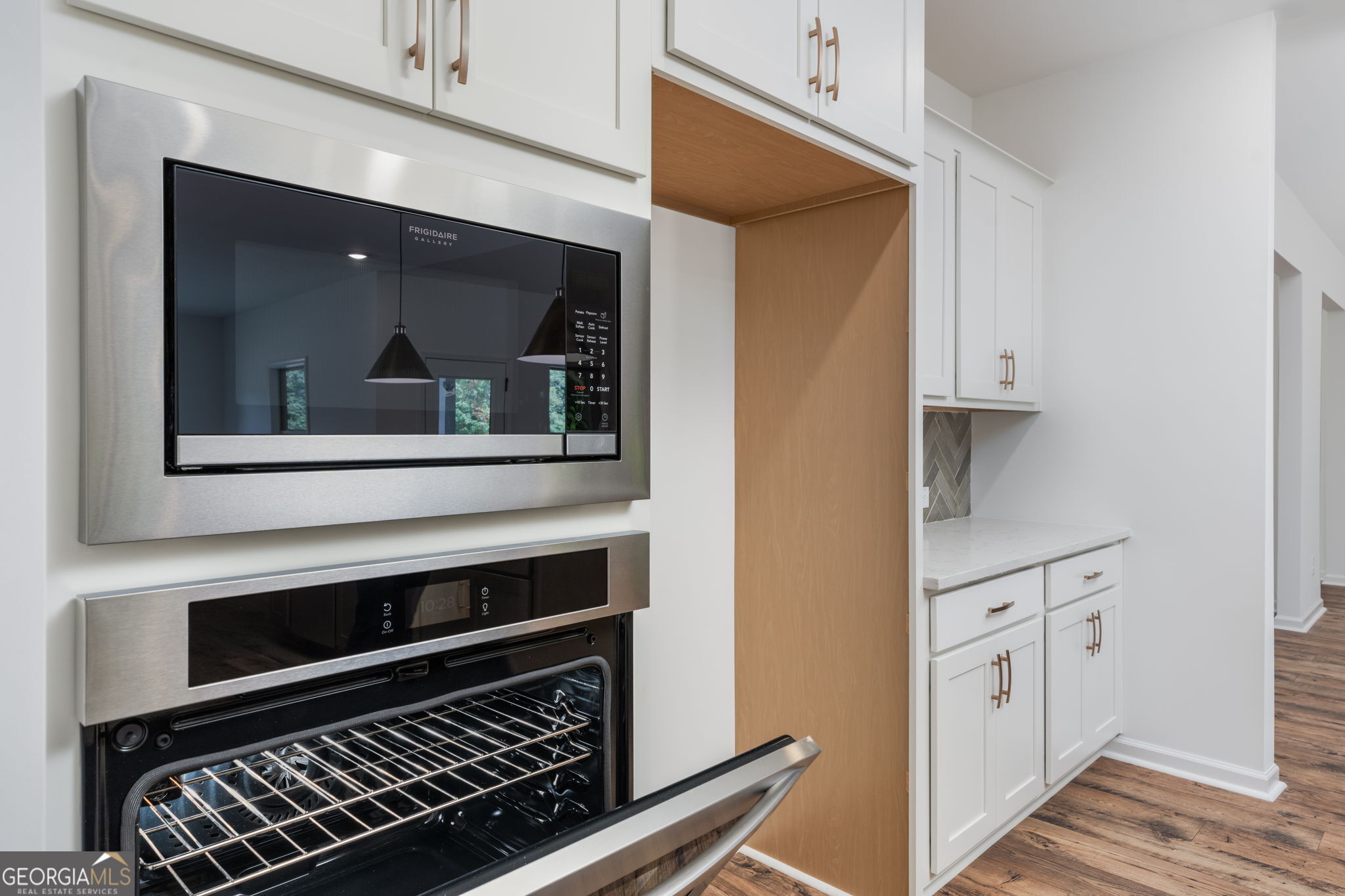 297 Bishop Road Meansville, GA 30256 - Photo 23 of 77 a kitchen with white cabinets and a stove