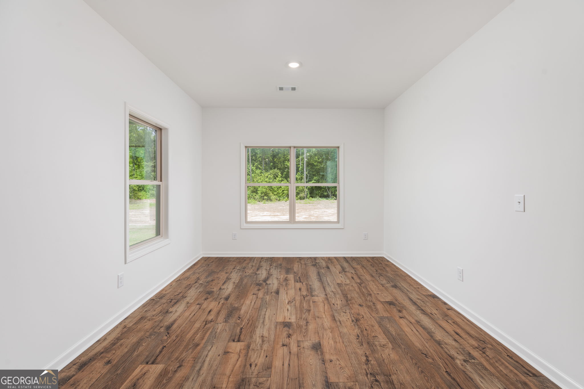 297 Bishop Road Meansville, GA 30256 - Photo 24 of 77 an empty room with wooden floor and windows