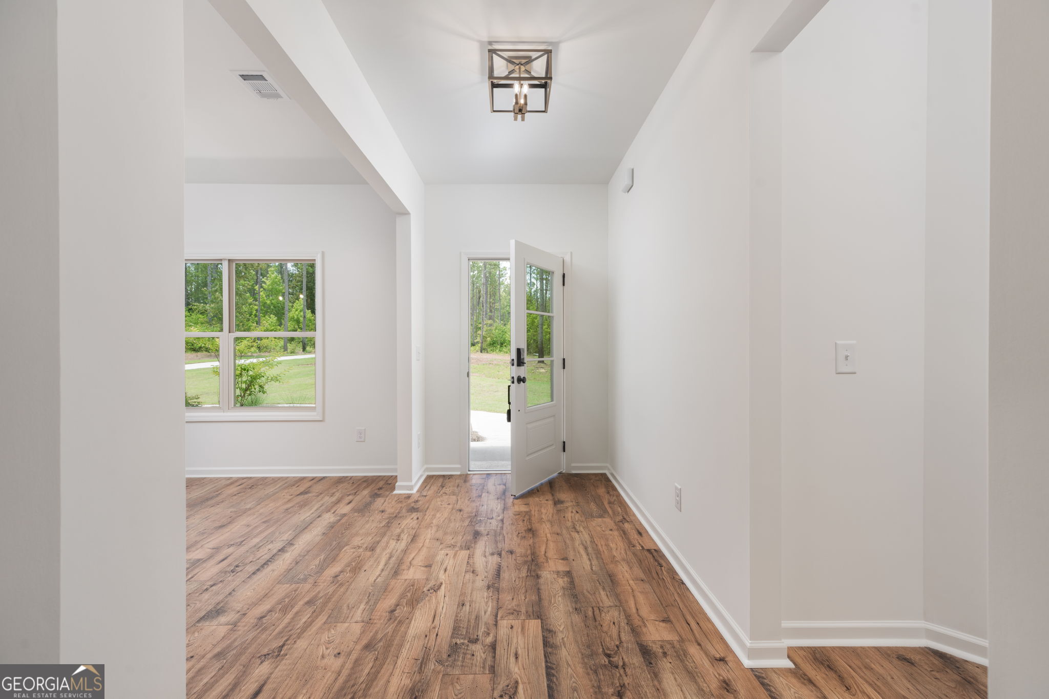297 Bishop Road Meansville, GA 30256 - Photo 6 of 77 an empty room with wooden floor and windows