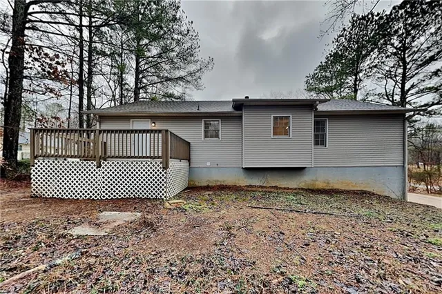 a view of a wooden house with a large window and wooden fence