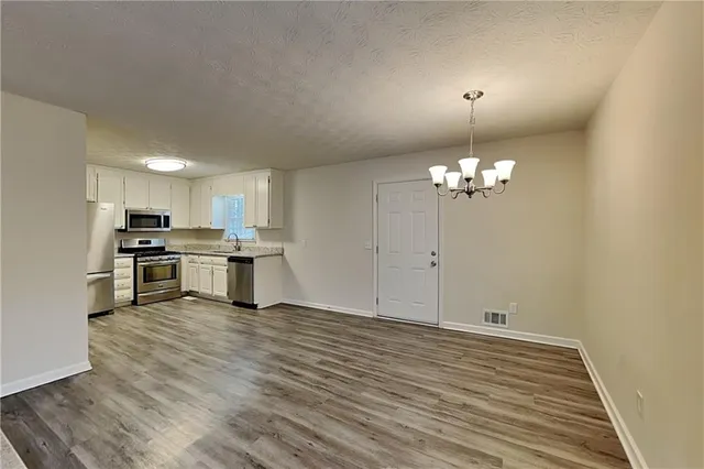 a view of kitchen with granite countertop cabinets and refrigerator