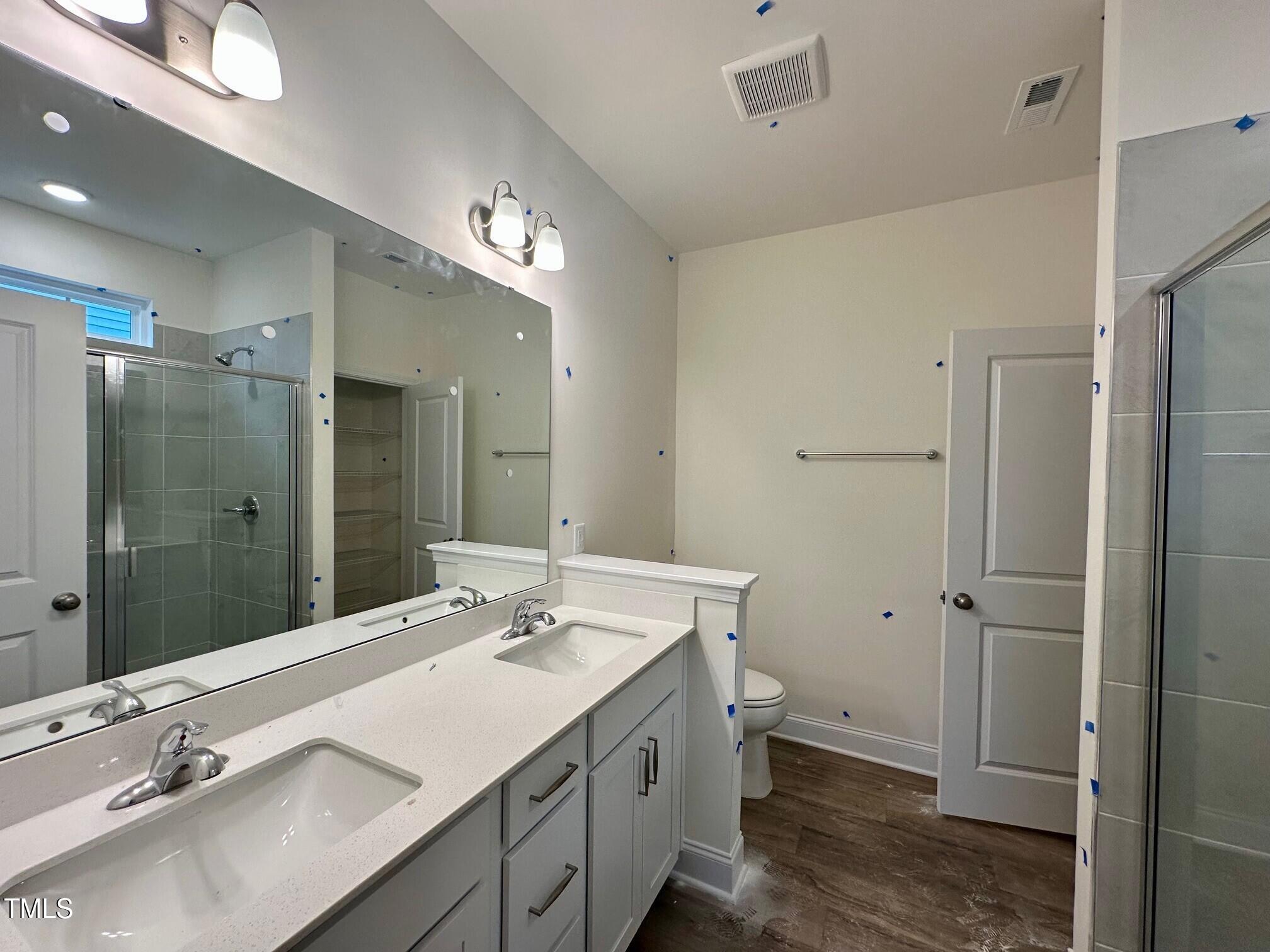 964 Channel Drop Loop Zebulon, NC 27597 - Photo 8 of 30 a bathroom with a double vanity sink toilet and shower