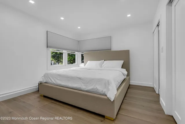 a bed sitting in a spacious bedroom next to a window