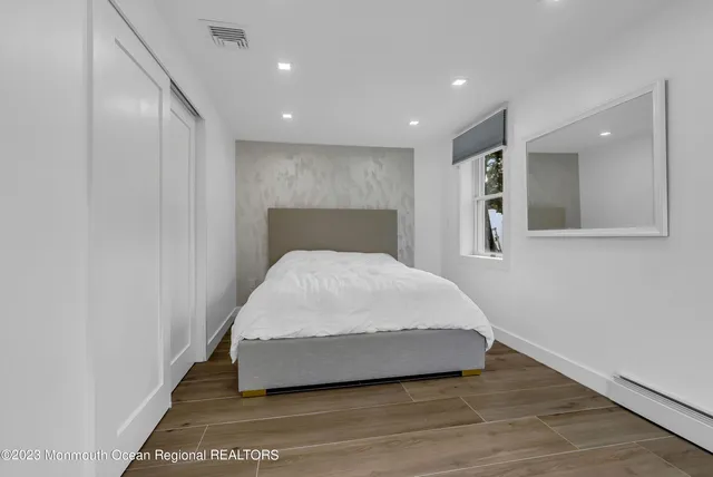 a large bedroom with a bed and a mirror