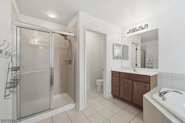 a bathroom with a bathtub shower sink mirror and toilet