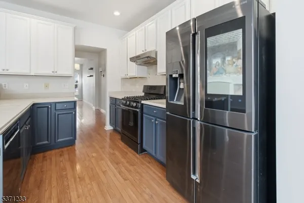 a kitchen with stainless steel appliances granite countertop a refrigerator and a stove top oven