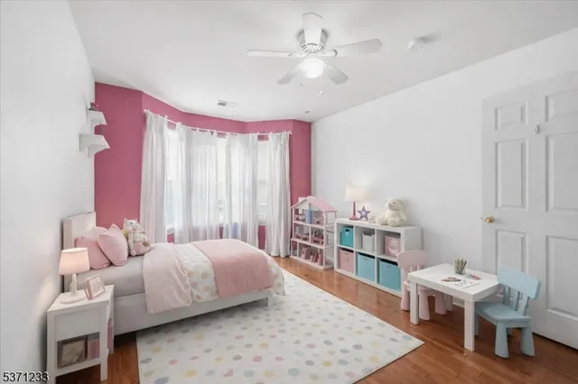 a bedroom with a bed wooden floor and furniture