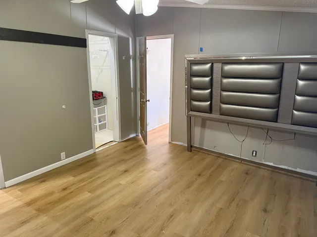 a view of empty room with wooden floor and window