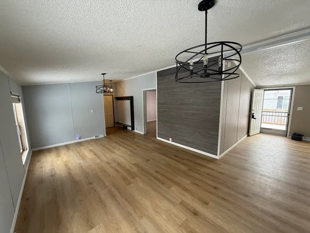 a view of a room with wooden floor and ceiling fan