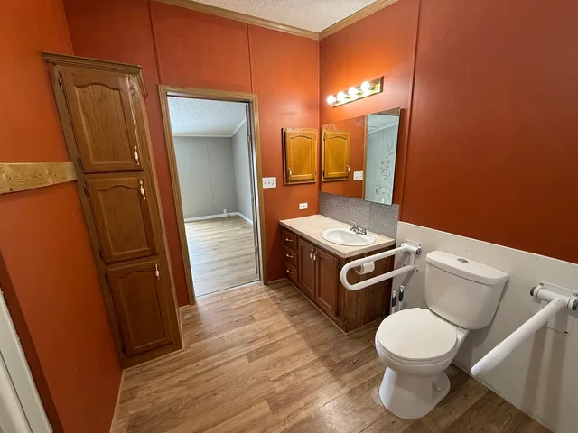 a bathroom with a toilet a sink and mirror