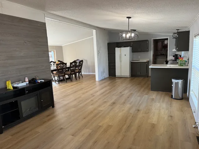 a kitchen with stainless steel appliances kitchen island granite countertop a sink dishwasher stove and oven with wooden floor