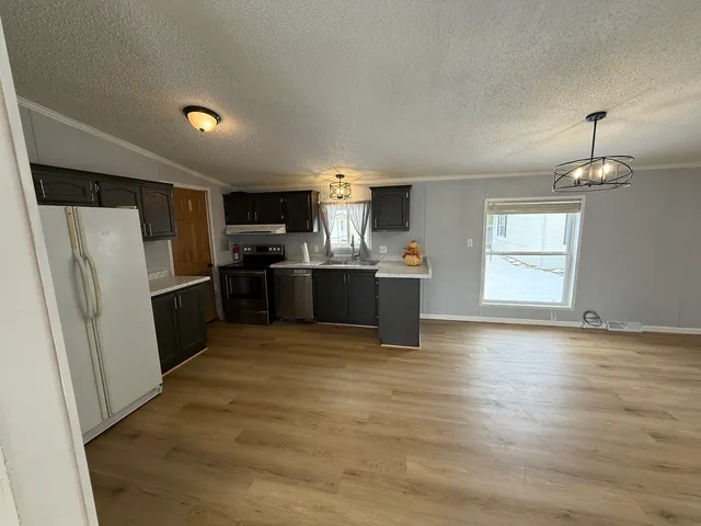a view of kitchen with refrigerator microwave and cabinets