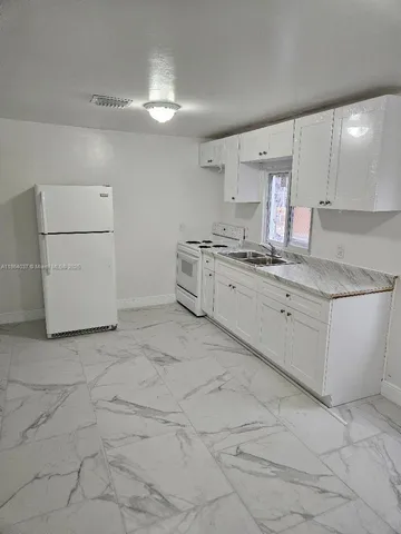 a kitchen with a stove a sink and a refrigerator